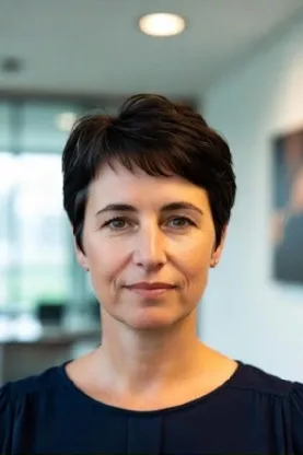 Mulher com cabelo curto, expressão confiante, em ambiente corporativo — imagem usada para depoimento de usuário da planilha