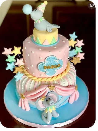 Bolo no Tema Circo com tons pastéis, foca no topo do bolo equilibrando bola no focinho e um elefante na base do bolo, estrelas espetadas no bolo do Curso Meu Primeiro Zoológico - Modele 25 Animais em Pasta Americana
