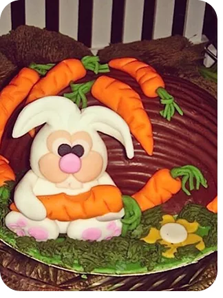 Bolo de 1 andar no tema Páscoa com cores fortes, no topo do bolo um coelho sobre um skate feito de cenoura e cenouras enterradas no bolo do Curso Meu Primeiro Zoológico - Modele 25 Animais em Pasta Americana