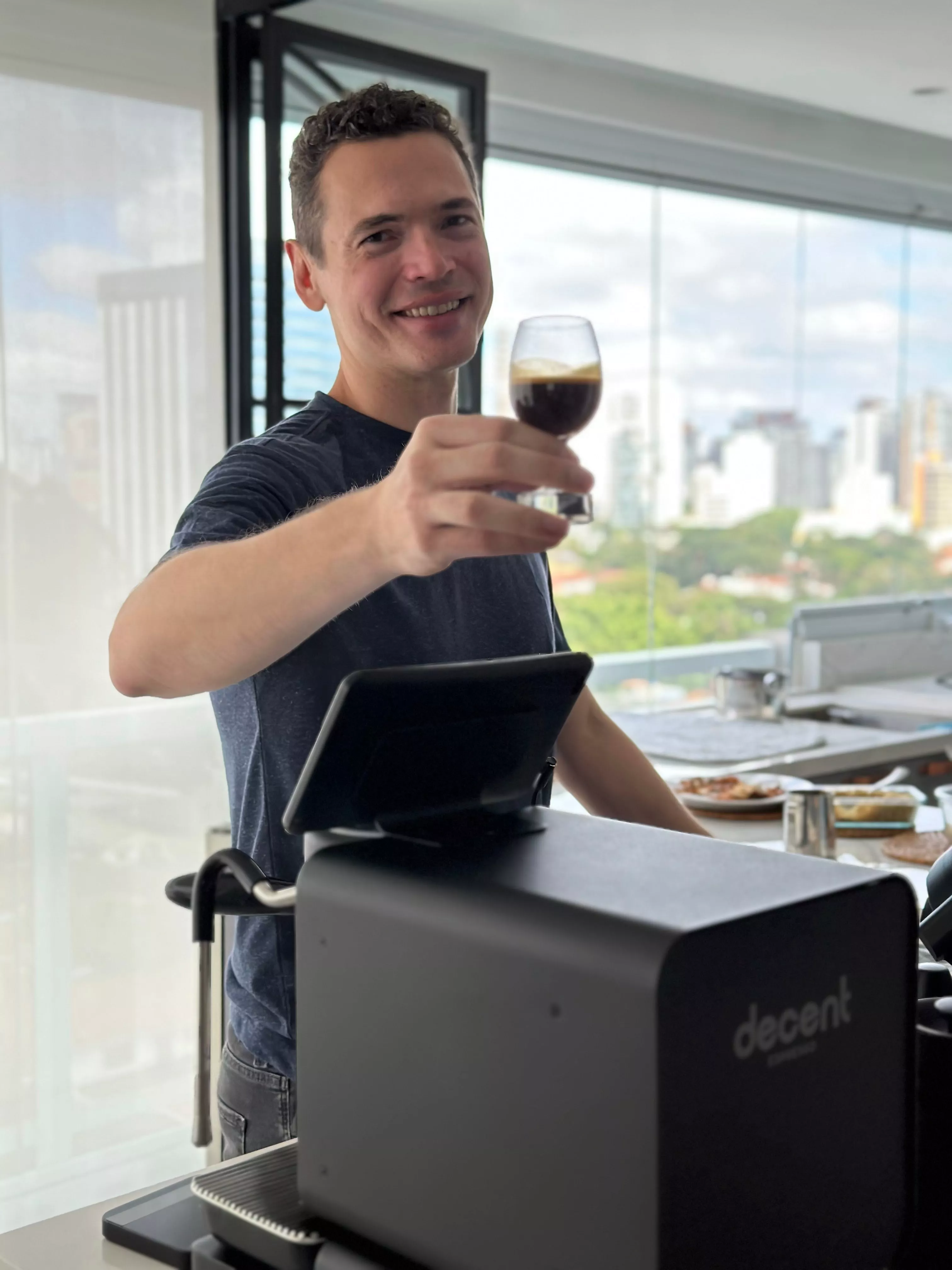 Alexandre Mandl - autor, barista e vendedor, segurando uma dose de espresso extraída por ele