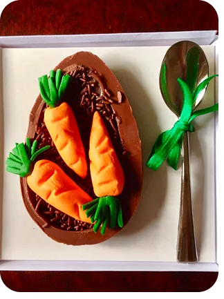 Ovo de Páscoa com cenouras sobre o brigadeiro simulando a terra do Curso Meu Primeiro Zoológico - Modele 25 Animais em Pasta Americana