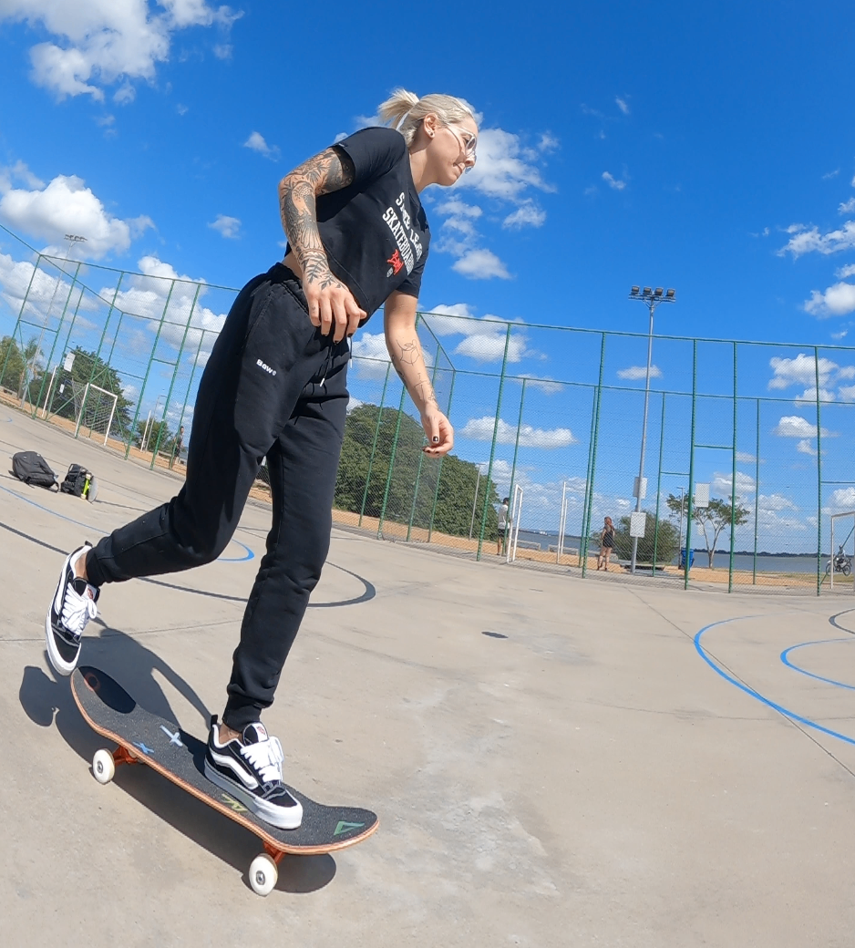 aluno andando de skate na quadra esportiva