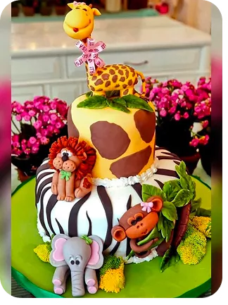 Bolo de 2 andares no tema Safari, com girafa no topo e leão, elefante e macaco na base, com os tons do próprio bolo em zebra e manchas de girafa, jardim na base do Curso Meu Primeiro Zoológico - Modele 25 Animais em Pasta Americana