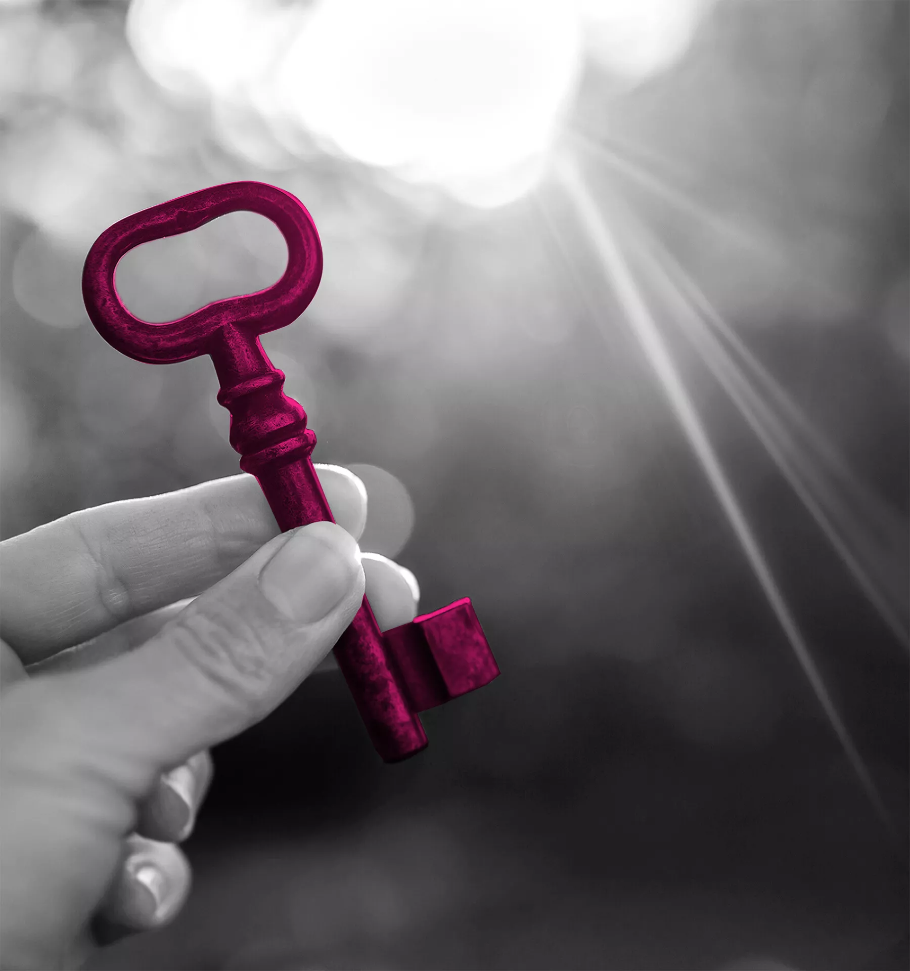 Una mano que tiene una llave de color magenta frente del sol