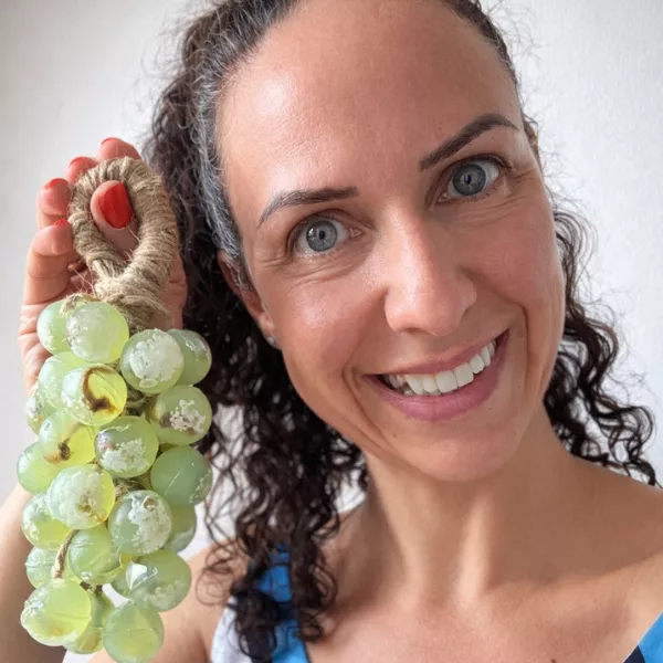 mulher sorrindo com sabonete cacho de uva na mão